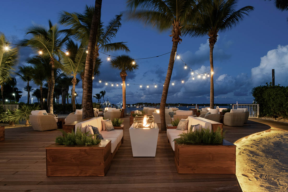 Infuse 360 Bar & Lounge seating area with fire pits and palm trees.